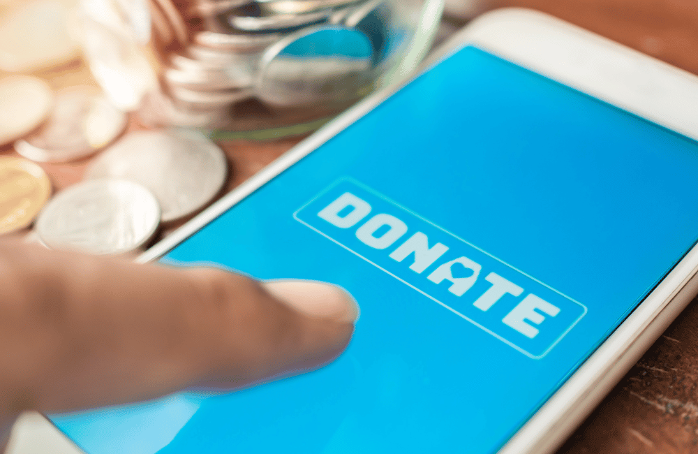 smartphone with a finger about to press the word "donate" on the screen