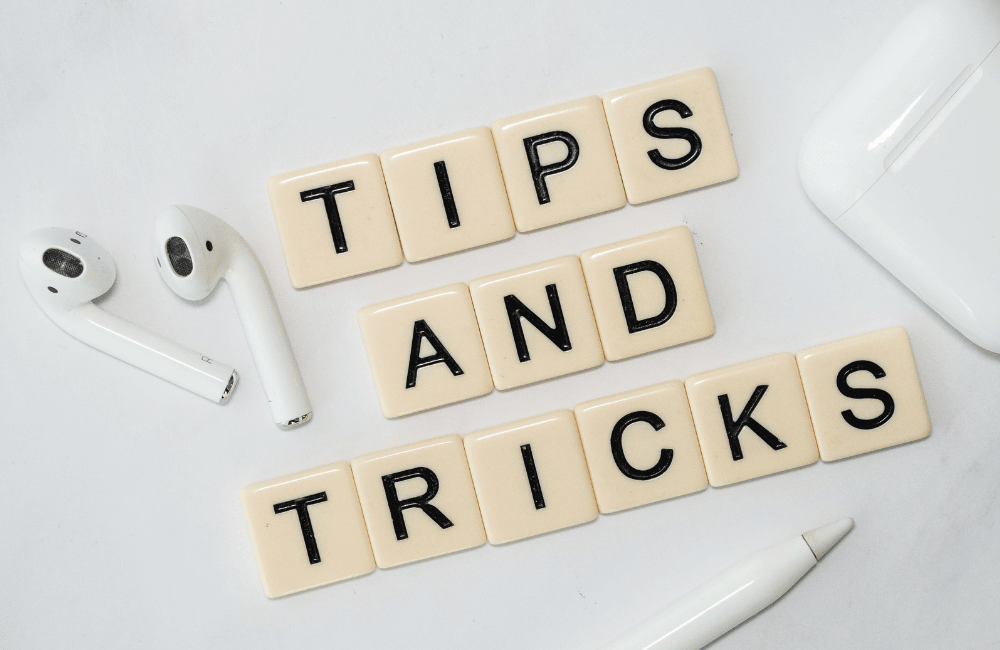 "Tips and Tricks" spelled out in scrabble letters with a pair of airpods and an apple pencil sitting nearby