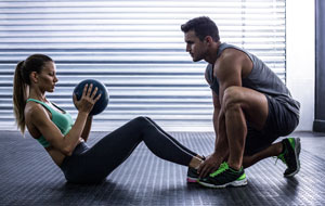 A personal trainer will be a popular auction item idea - photo of a personal trainer and trainee doing situps