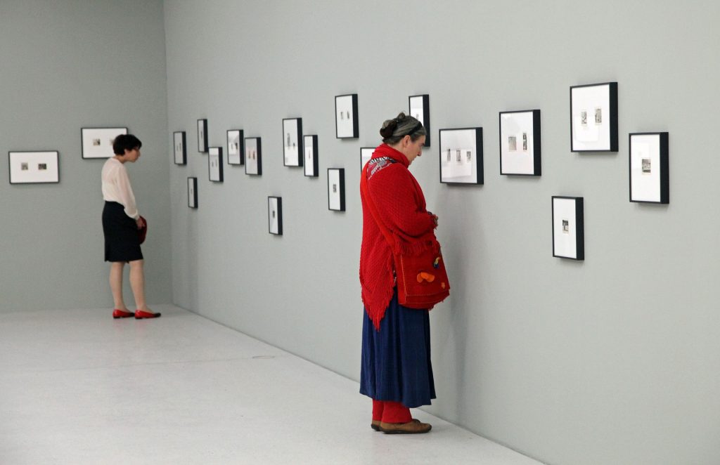 Women enjoying an art exhibition. This type of fundraising event can be hosted with only a handful of volunteers.