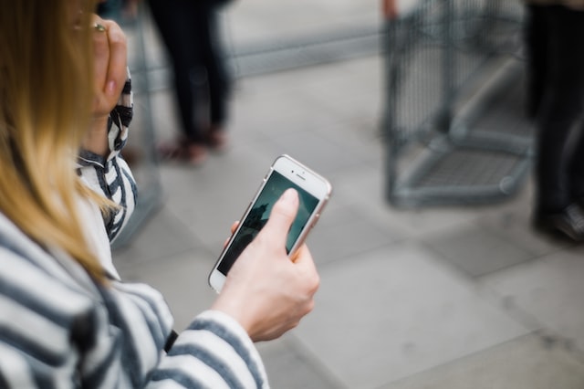 person on phone checking fundraising on facebook