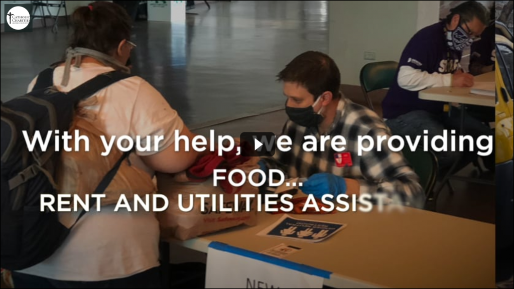 Screengrab of Catholic Charities of Denver's COVID-19 fundraising appeal video. The image shows their masked volunteers at work providing for those they serve.