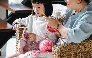 Little girl knitting with her mother