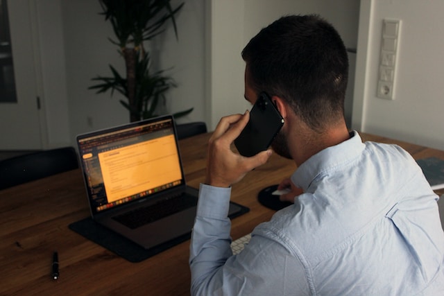 man looking at his computer asking for a donations over the phone