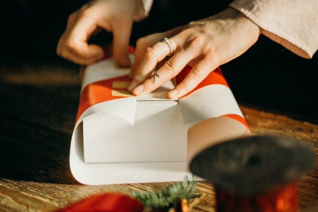 person wrapping a gift for holiday fundraising ideas