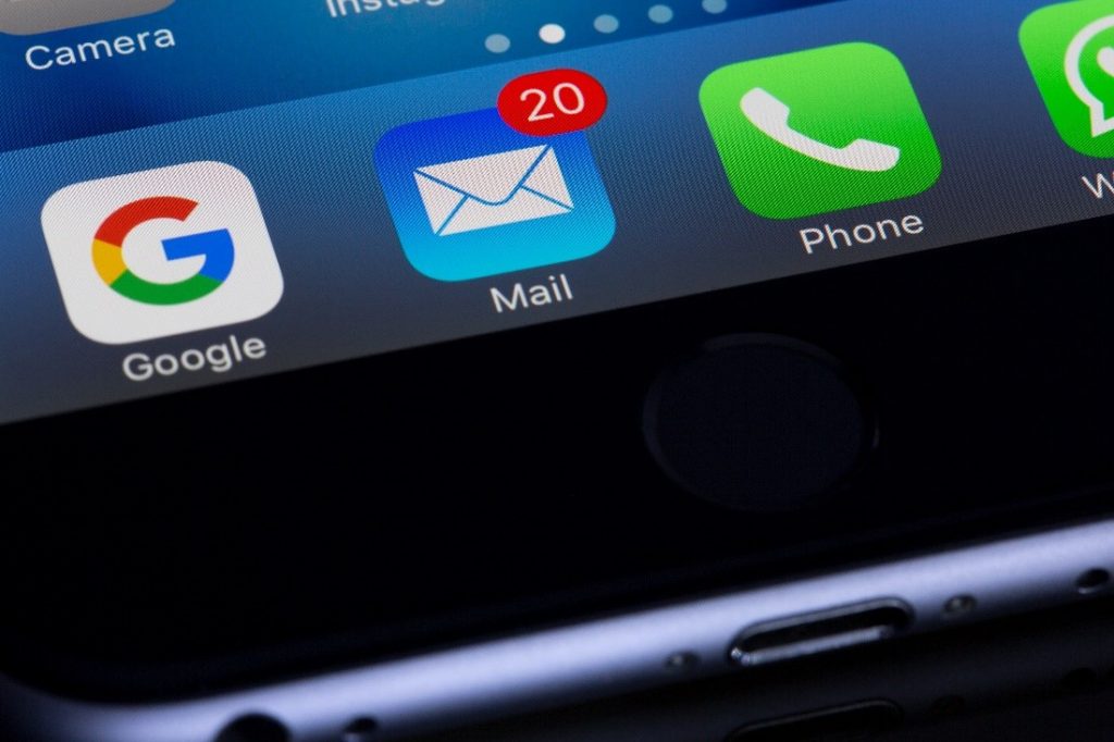 Image of communication app icons on a cell phone screen. The main icon is the email icon.