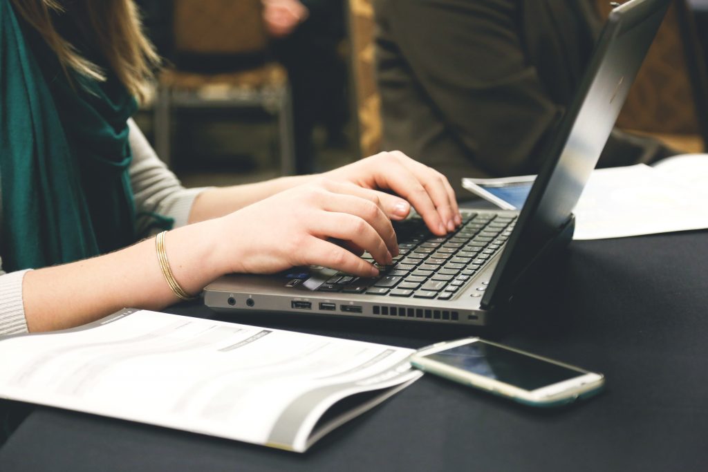 Woman writing a grant on a laptop.