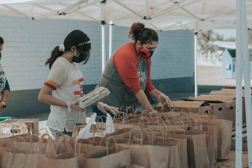 People filling food donation bags.