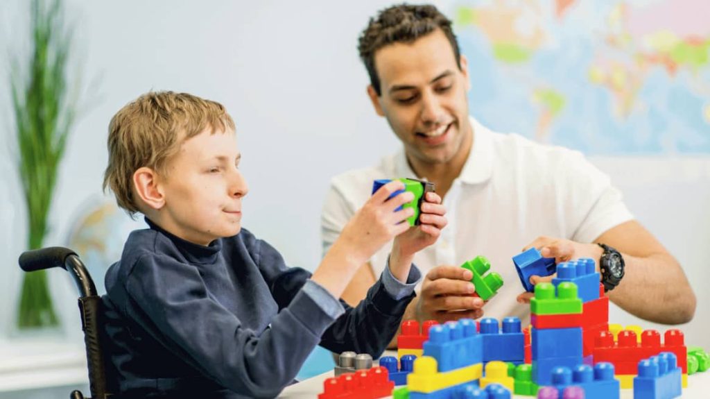 Father and son playing with legos/duplo and celebrating disability pride month