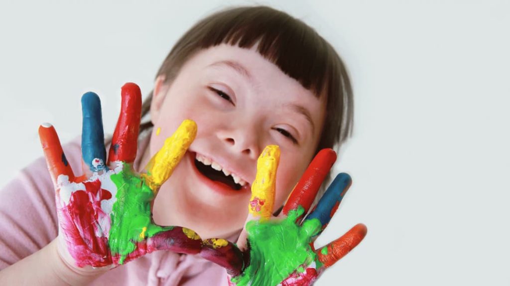 Young girl smiling with paint on hands