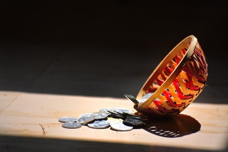 coins in a collection basket to show why online giving for churches helps increase funds