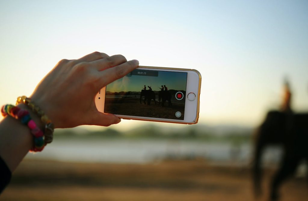 person taking a video with a phone to market their year-end giving campaign