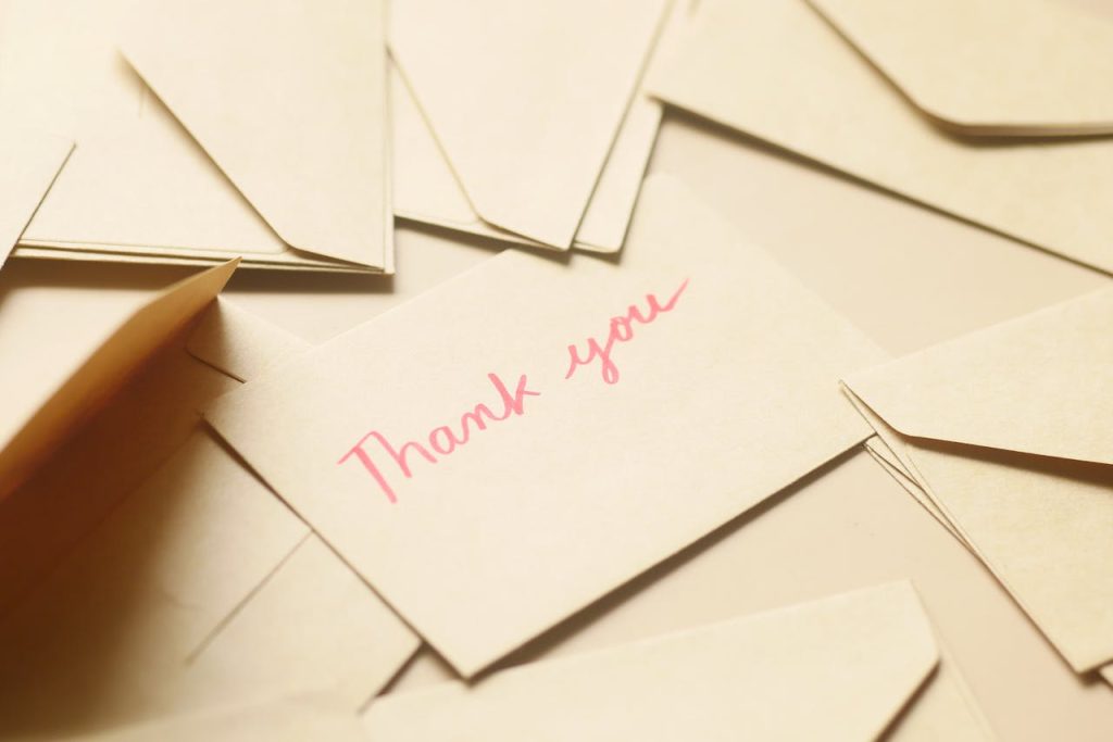 thank-you letters on a surface - use thank you letters to keep your donors engaged after their year-end donation 