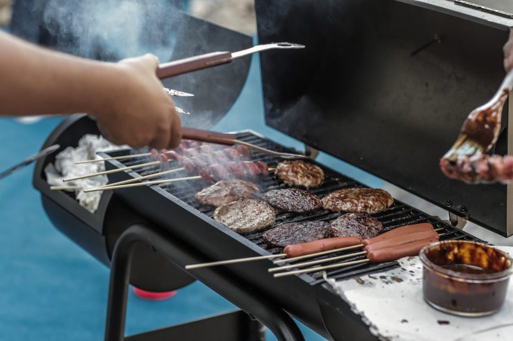 someone grilling hot dogs and hamburgers at a cook off for spring fundraising ideas