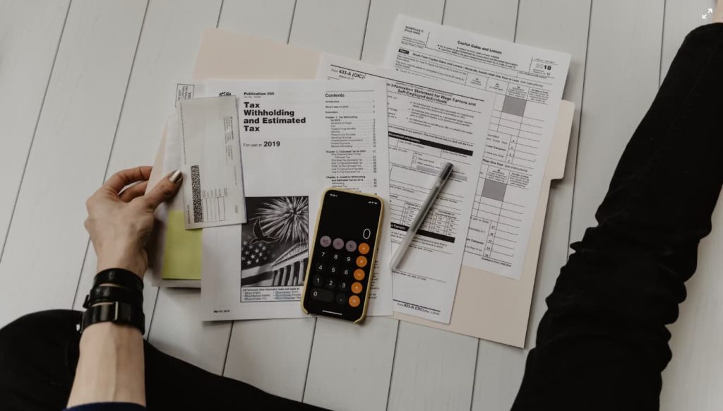 irs tax paperwork on floor with calculator