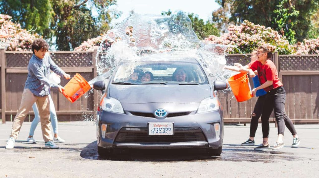 four kids washing a car at a fundraising event for kids